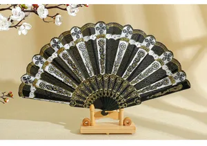 Dettaglio di un ventaglio pieghevole spagnolo con eleganti stampe floreali dorate.