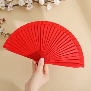 Elegante abanico español plegable de madera roja sobre fondo beige con flores