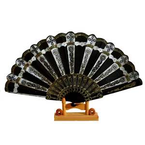 Elegante ventaglio spagnolo nero con bronzatura dorata e motivi floreali bianchi.