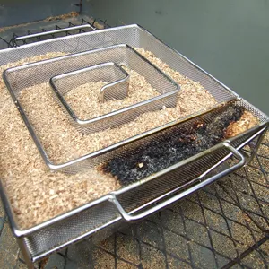 Square stainless steel cold smoke generator mesh tray filled with wood sawdust for BBQ smoker