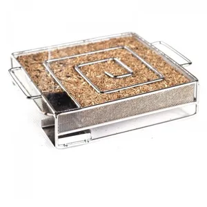 Close-up of stainless steel cold smoke generator filled with wood sawdust