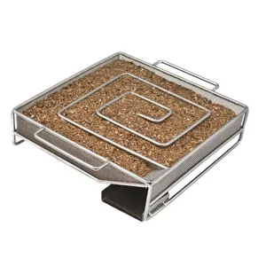 Macro view of a square stainless steel cold smoke generator tray filled with fine wood chips.