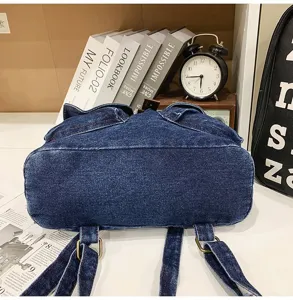 Close-up of the durable denim fabric and reinforced bottom of this stylish blue backpack.