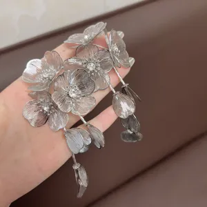 Dettaglio ravvicinato di orecchini a fiore in argento con nappe e zirconi brillanti