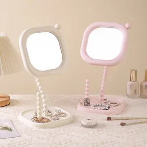 Elegant bubble-stem desktop makeup mirror with integrated jewelry tray in pink and cream