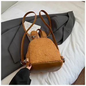 Vista detallada de una linda mochila de felpa marrón con orejas de conejo y base de cuero