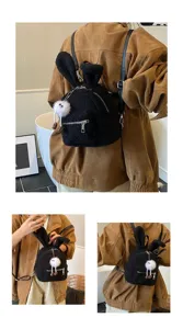 Vista detallada de la mochila de peluche negra con orejas de conejo para niños en tela suave