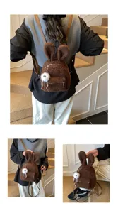 Mini mochila de peluche marrón con orejas de conejo y adorable pompón blanco.
