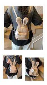 Detalle de mochila de peluche con orejas de conejo para niños, textura suave y colgante