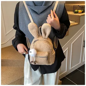 Vista detallada de una mochila de peluche con orejas de conejo y un amuleto suave