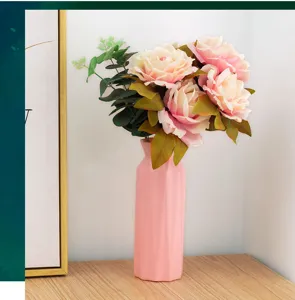 Vaso geometrico rosa in plastica con rose artificiali per decorazione d'interni