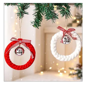 Détail de couronnes de Noël tricotées avec cloches argentées et nœuds rayés.