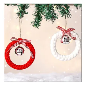 Gros plan d'ornements de couronne de Noël tissés rouge et blanc avec clochettes en argent