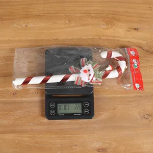 Vue détaillée d'une décoration de canne en sucre de Noël pesant 22,8g sur balance