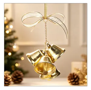 Detailed view of three golden Christmas bells hanging with a shimmering ribbon bow