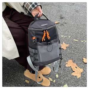 Detail of black technical backpack with mesh pocket and orange drawstring accents
