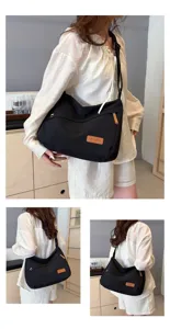 Vue détaillée d'un sac bandoulière noir simple grande capacité sur un mannequin