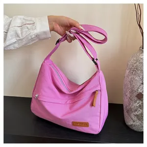 Vue détaillée du sac à bandoulière en tissu rose avec sangle réglable et étiquette
