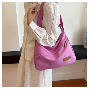Mannequin portant un grand sac hobo en toile rose avec une robe blanche élégante