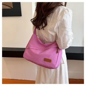 Grand sac bandoulière en toile violette porté par un mannequin