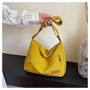 Vue détaillée d'un grand sac bandoulière jaune élégant en nylon pour un usage quotidien