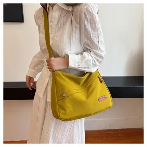 Vue détaillée d'un sac bandoulière en toile jaune vif avec un patch FASHION brodé