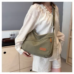 Vue détaillée du sac bandoulière en toile vert olive porté par un mannequin