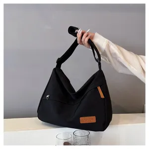 Détail d'un grand sac bandoulière décontracté en toile noire avec écusson FASHION