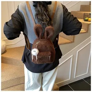 Vista trasera detallada de una linda mochila de felpa marrón con orejas de conejo en un modelo