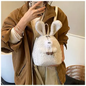 Detalle de una mochila de peluche blanca con orejas de conejo y colgante de pompón suave