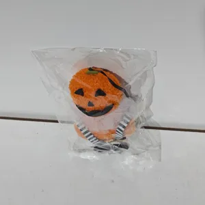 Halloween pumpkin plush hanging ornament shown inside clear plastic packaging bag