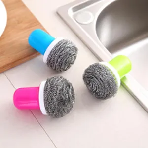 Detailed shot of three steel wool scrubbing brushes with colorful handles near kitchen sink