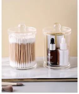 Detailed view of clear acrylic canisters storing cotton swabs and cosmetic bottles.
