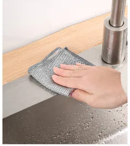 Detail of silver wire mesh cleaning cloth scrubbing a stainless steel sink surface