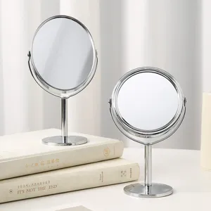 Elegant dual-sided desktop makeup mirrors in silver finish on a minimalist desk