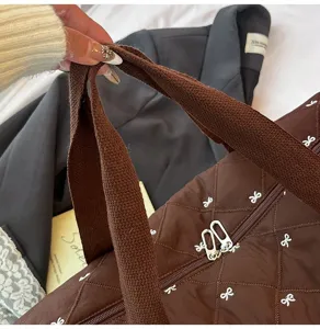 Brown quilted travel duffel bag with cute white bow embroidery for lightweight sports fitness use.
