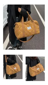 Detail view of brown quilted travel duffel bag with bow patterns and crossbody strap outdoors.
