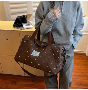 Quilted travel duffel bag with cute bow pattern, casual brown shoulder bag for women daily use.
