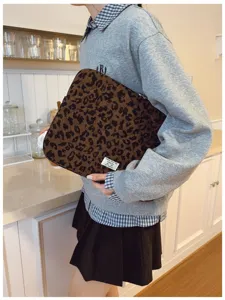 Close-up of stylish leopard print laptop sleeve held in a lifestyle setting