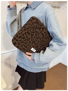 Premium leopard print laptop sleeve protector held by a model in a stylish outfit