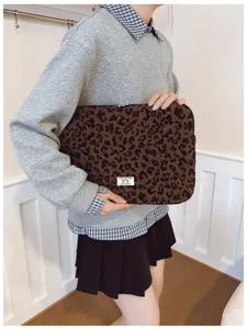 Close-up of a stylish leopard print laptop sleeve shown for scale in a lifestyle setting