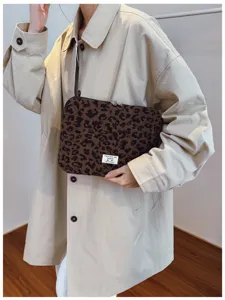 Detailed macro view of a stylish leopard print corduroy laptop sleeve on a model