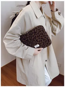 Stylish leopard print corduroy laptop sleeve held by a model in a beige trench coat