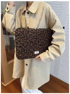 Leopard print laptop sleeve held by a model wearing a stylish beige trench coat