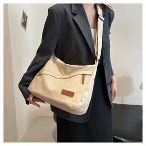 Vue détaillée d'un sac messager en toile beige minimaliste de grande capacité
