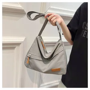 Vue de face d'un sac à bandoulière gris minimaliste en nylon de grande capacité
