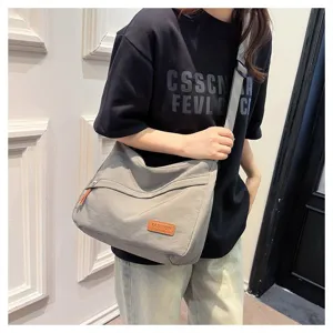 Sac bandoulière décontracté en toile grise à grande capacité porté par un mannequin