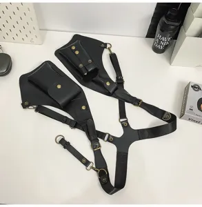 Detail of black tactical holster vest bag with multiple pouches and brass hardware