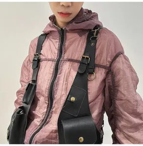 Detail shot of black faux leather tactical vest bag with adjustable straps and metal buckles.