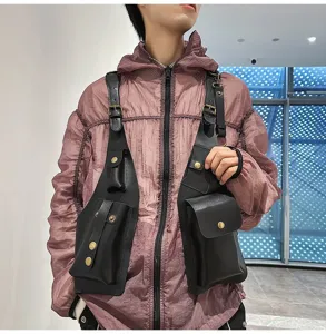 Close-up detail of a men's black tactical vest chest bag worn over a purple jacket